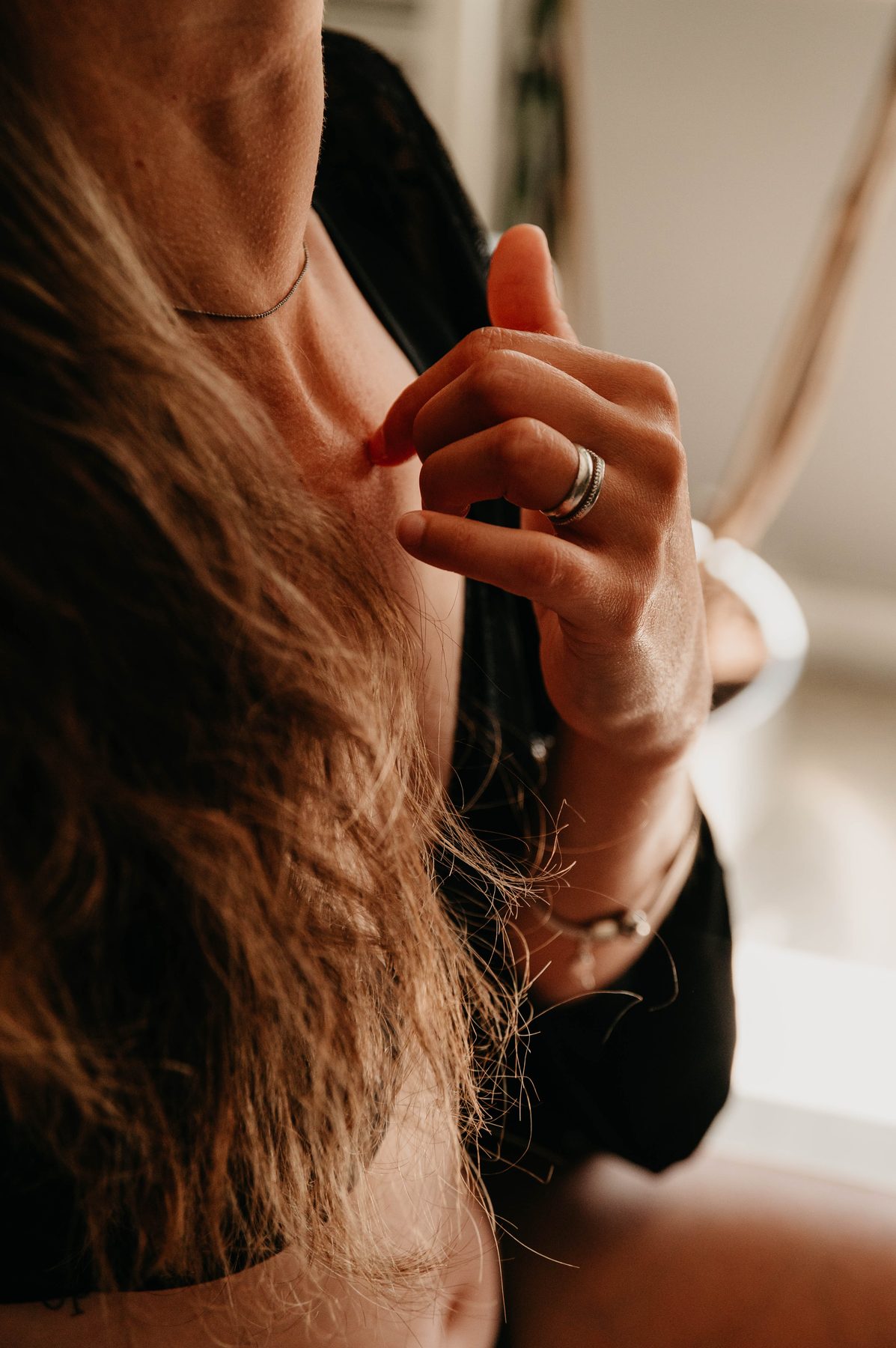 Gros plan sur des cheveux et une main ornée d’une bague, détail intime